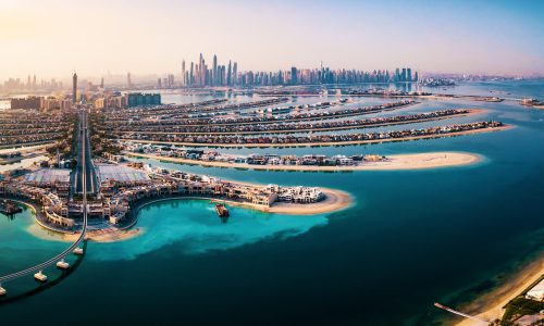 The Palm island panorama with Dubai marina rising in the background aerial view